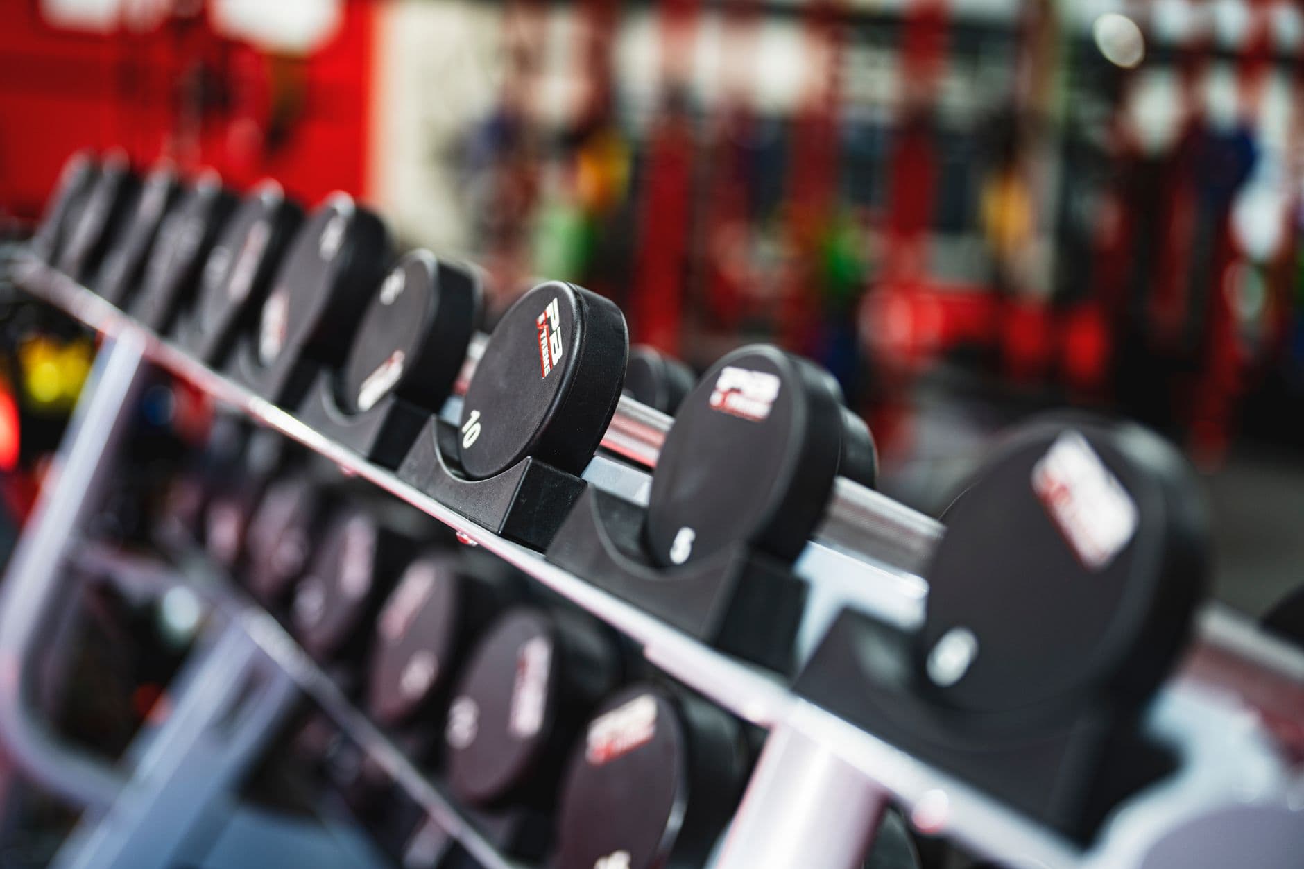 A rack of dumbbells along a gym wall